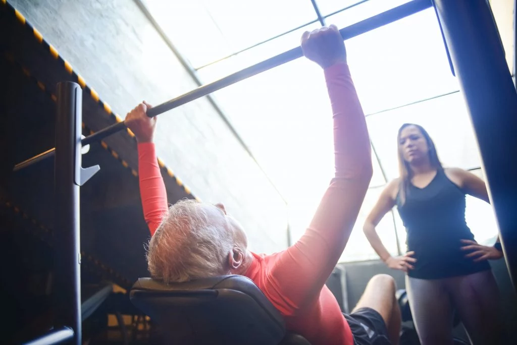 Female weight loss coach supervising a client during strength training.