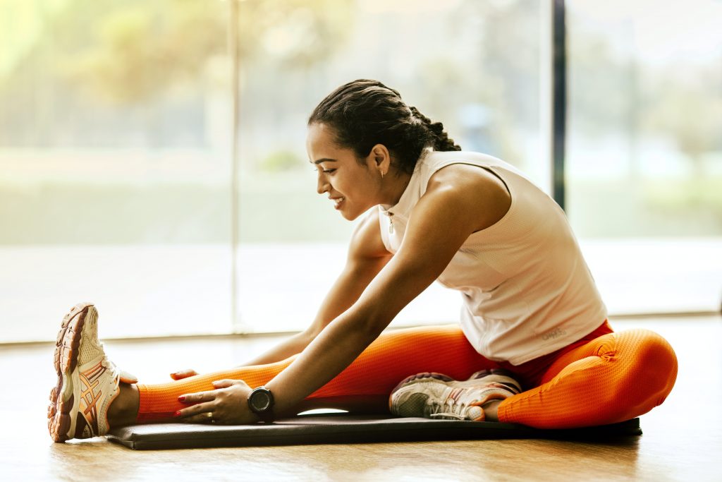 A woman is stretching her body and does one the physical movements