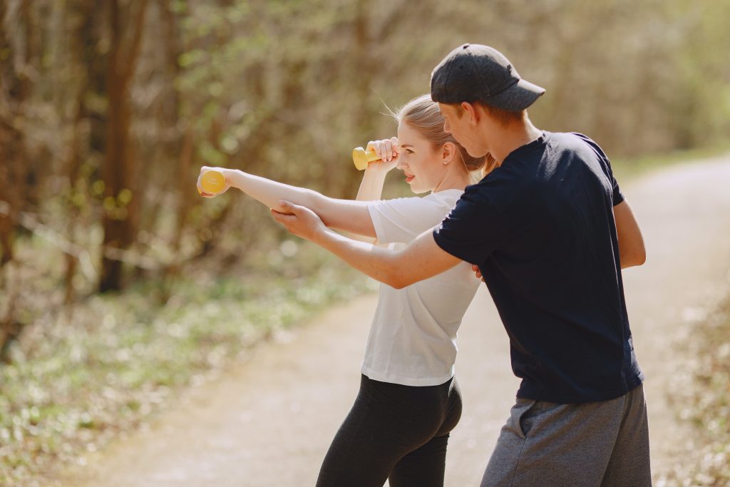 a trainer shows his trainee how to move her hands