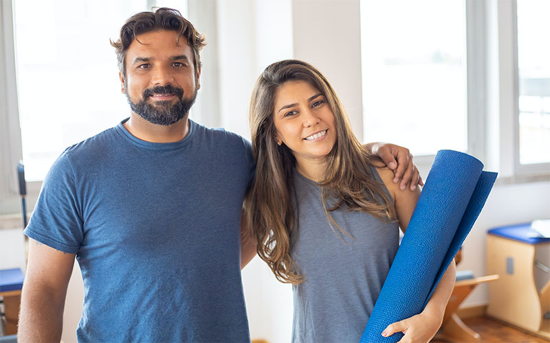 A trainer and his trainee are posing for taking a picture