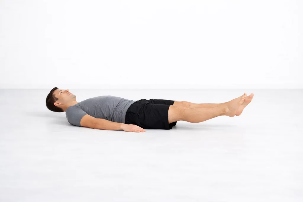 Active Isolated Stretching exercise with a man lying on his back performing a controlled double leg raise to improve core strength and lower body mobility.