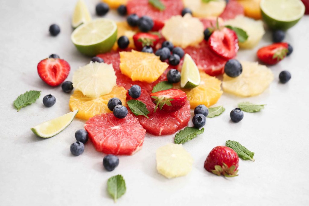 citrus-fruits-berries-leaves_11zon A vibrant mix of citrus slices, berries, and fresh mint leaves.