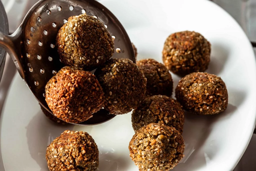 Golden-brown falafel with sesame seeds, freshly fried and ready to serve.