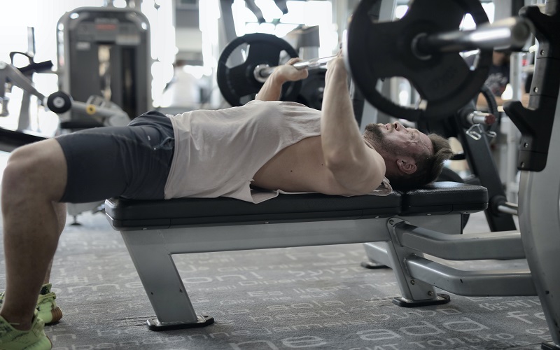 A man is at the gym practicing a bench press for working on his chest muscle as compound exercise 