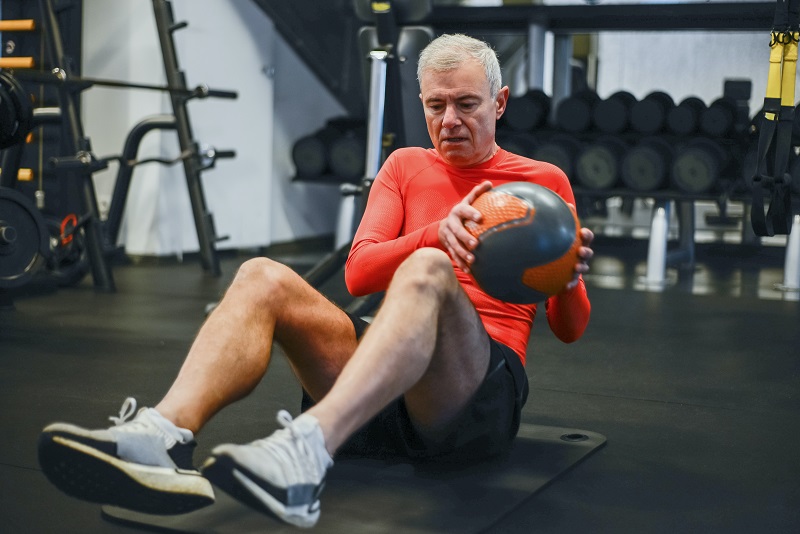 An absolute beginner is using a ball to exercise