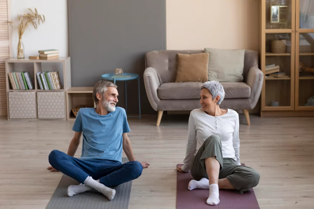 A senior couple exercising together at home, showing how online personal training for seniors supports active aging.