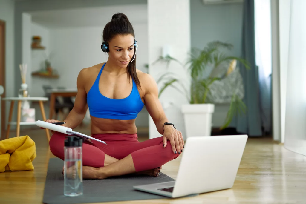 female-fitness-instructor-having-online-consultations-while-using-computer-living-room