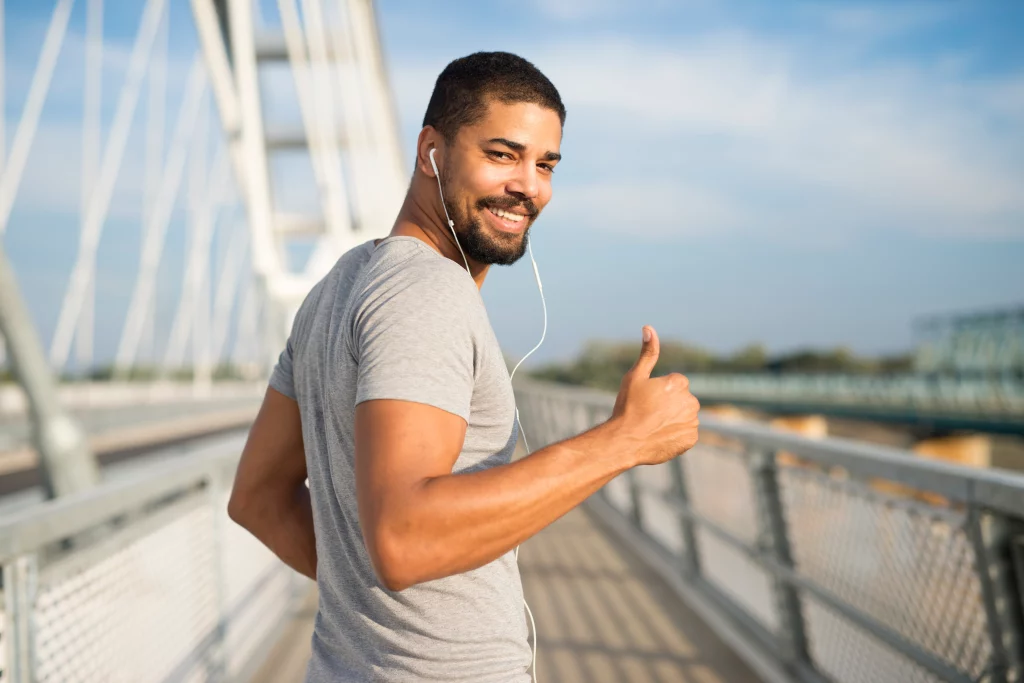 A man going for a run outdoors as part of a program designed by his online fitness trainer.