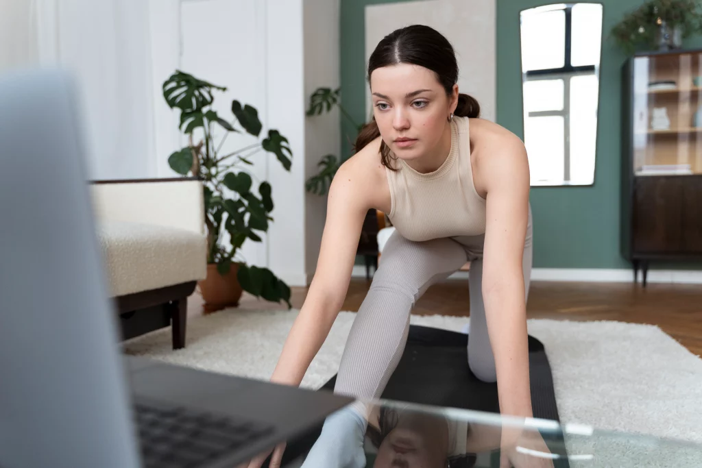 Focused woman following an online personal training session at home to overcome gym anxiety