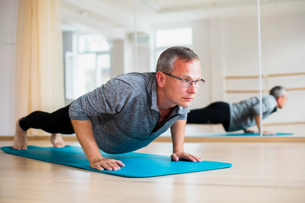 A middle-aged client improving strength and mobility with an online personal trainer for men over 40 during a home workout