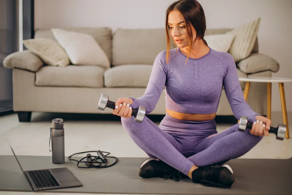 A woman listening to her virtual personal trainer during a home workout focused on female muscle gain.