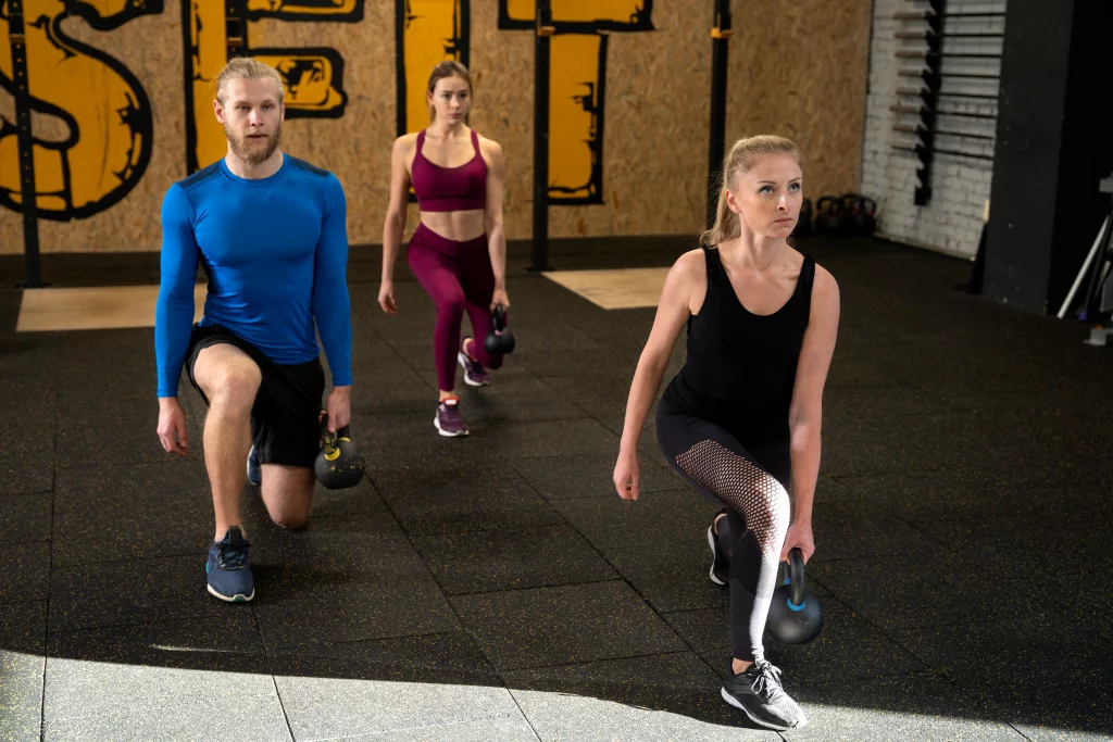 young-adults-sport-gym-using-kettlebells Clients performing kettlebell lunges during a personal training session in Vancouver