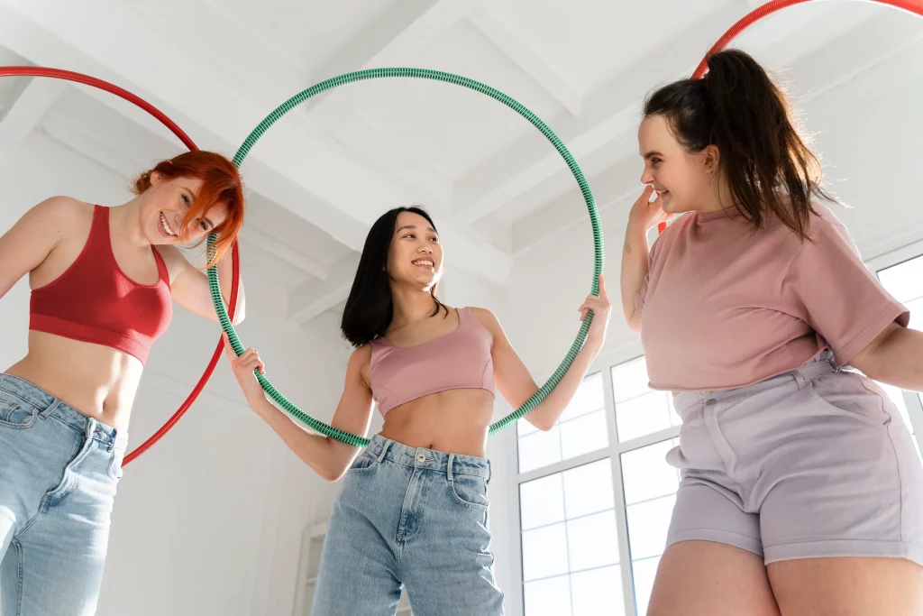 young-women-with-hula-hoops Teen girls enjoying physical activity together as part of a healthy approach to weight loss in teens.